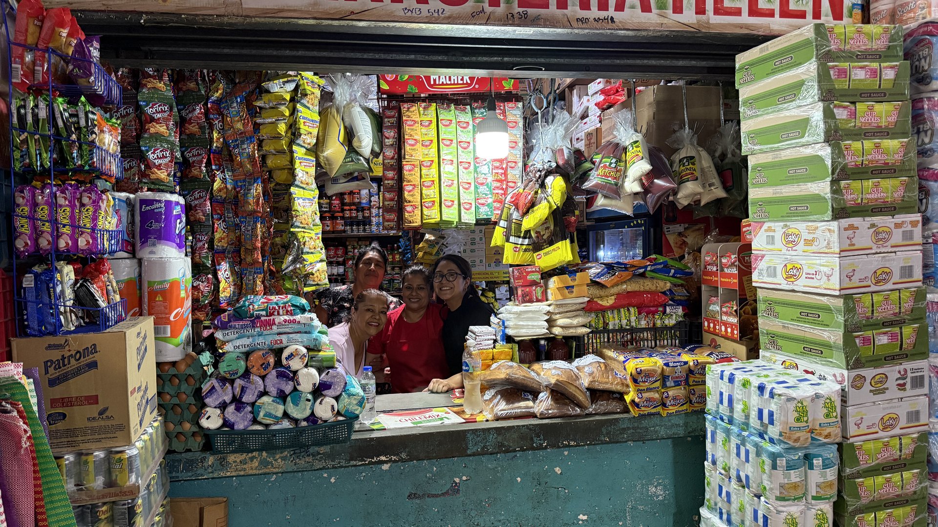 El equipo de Abarrotería Hellen detrás del mostrador lleno de productos